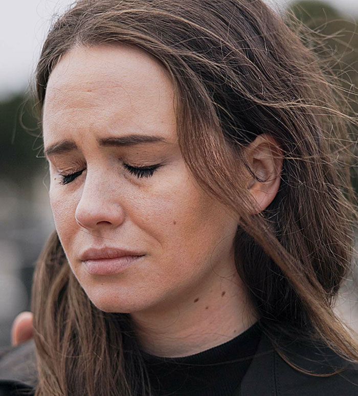 A young woman with closed eyes and a pained expression. Her disheveled hair suggests a cringe-worthy or scary first date.
