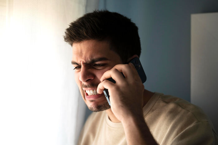 Frustrated man angrily talking on phone about pizza delivery customer issue