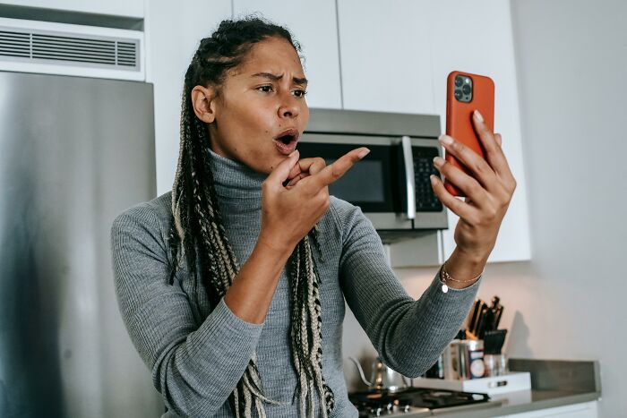 Frustrated woman arguing on smartphone at home