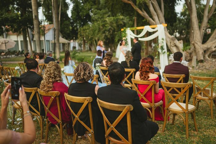 Outdoor wedding ceremony with guests seated and bride and groom at altar