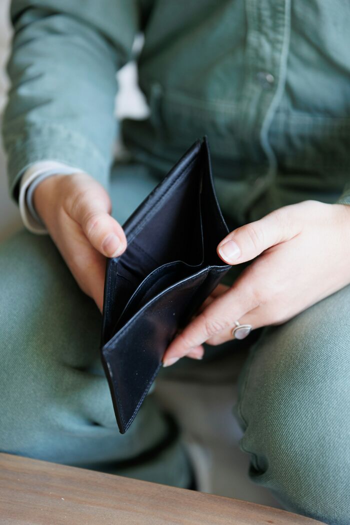 Person holding empty wallet illustrating personal finance and economic hardship