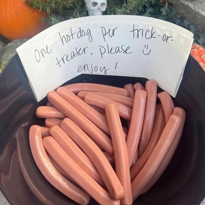 Bowl of hot dogs with a note offering one hot dog per trick-or-treater for Halloween