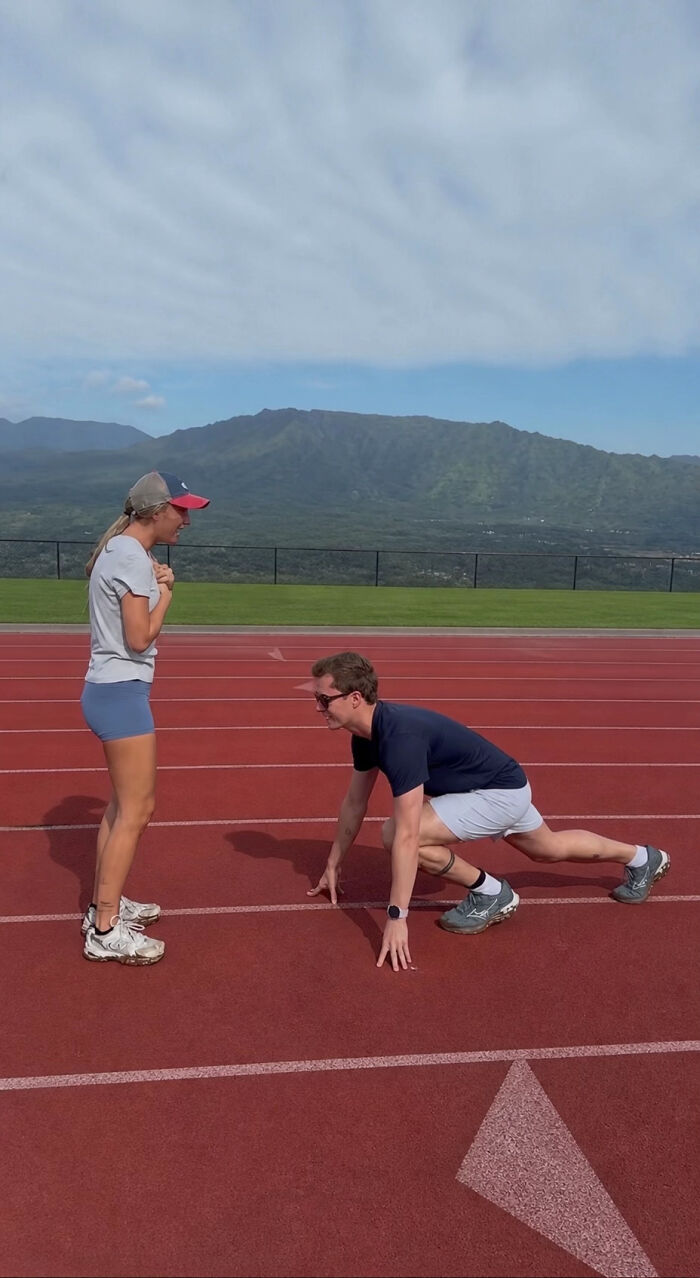 A man in a starting position on a track, proposing to a woman. A beautiful proposal pic and viral edits.