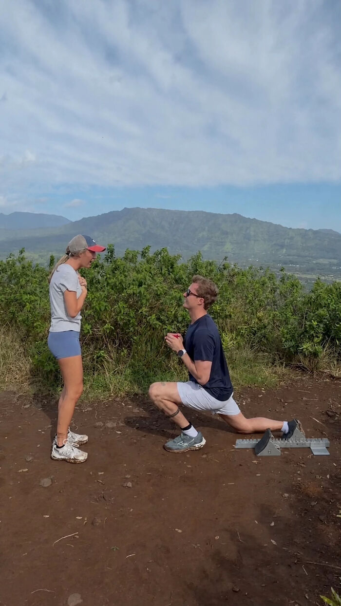 Man proposing to a woman on a mountain top. This viral proposal pic inspired hilarious edits.