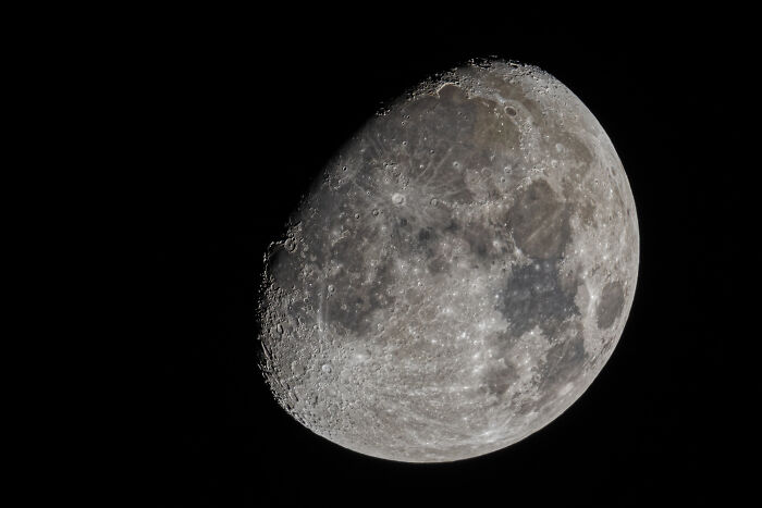 A detailed image of the moon's surface, showing craters and maria against a black sky. Wild encounters and intelligence.
