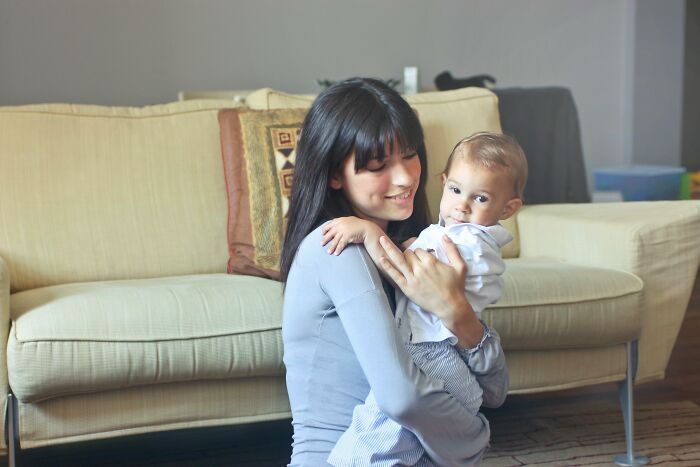 Woman smiling and holding baby in living room