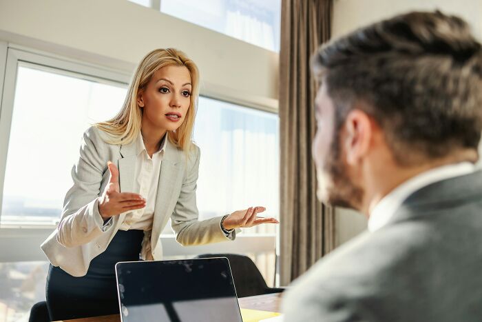 Businesswoman speaking passionately during office meeting about peace over paycheck decision