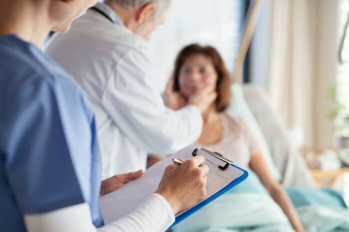 Medical staff examining a patient in hospital room