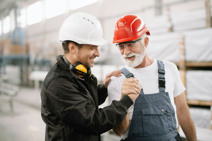 Workers shaking hands wearing helmets in industrial setting scary inevitable moments