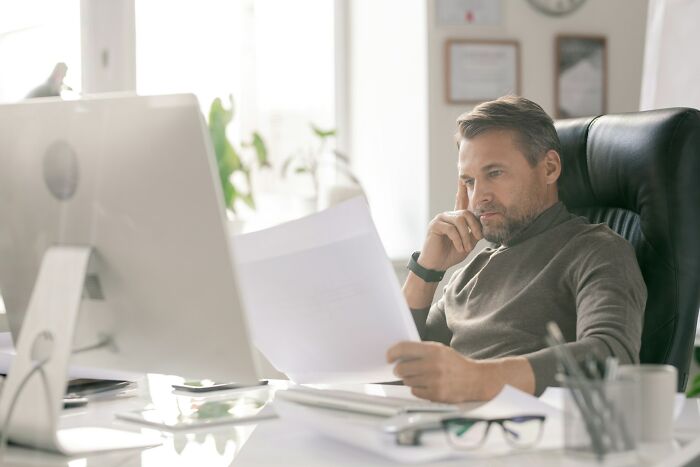 Man focused reading document at his desk, laziness saving people work