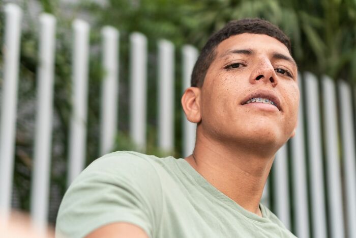 A young man with freckles and braces looks up, wearing a light green shirt, suggesting epic comebacks.