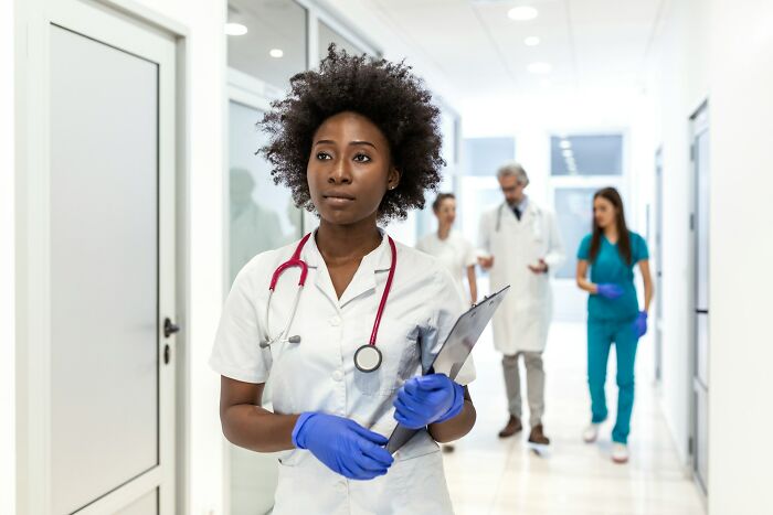 Medical staff in psychiatric facility hallway with stethoscope and clipboard