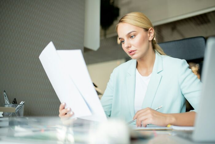 Focused woman reviewing documents at office desk