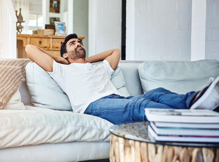 Man relaxing on couch unaware of upcoming unexpected disaster