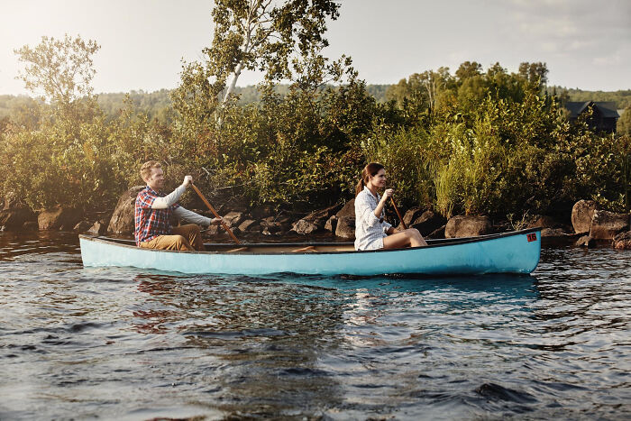 Couple canoeing on lake amid nature during unexpected disaster