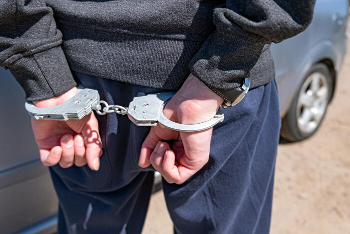 Person in handcuffs detained after unexpected disaster