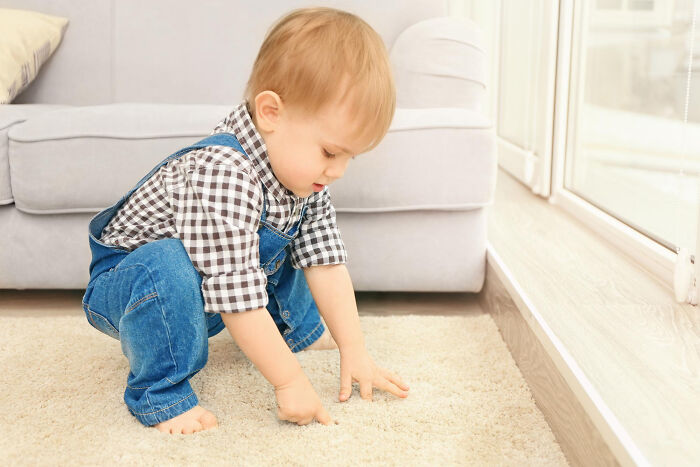 Toddler playing on carpeted floor indoors