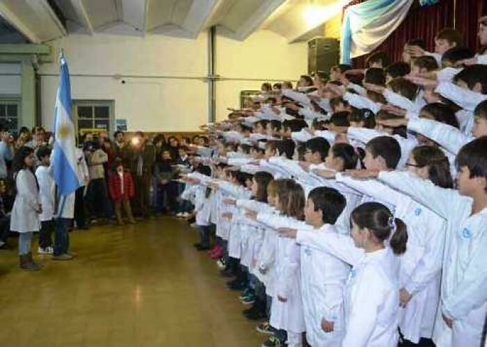 Children in white uniforms participating in an unusual local school ceremony