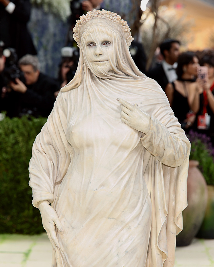Heidi Klum's Met Gala outfit: a statue-like figure with veiled face and a flower crown. Genuinely disturbing transformation.