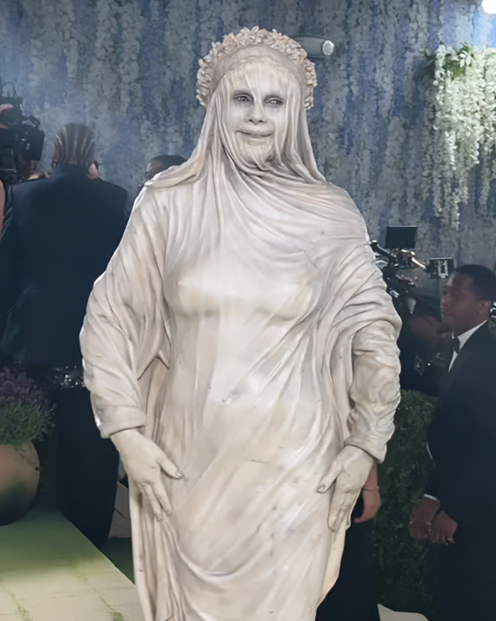Heidi Klum's Met Gala outfit: a disturbing, white, draped costume with a veiled face, evoking a statue.