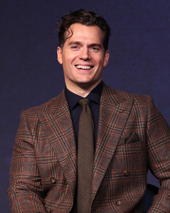 Henry Cavill smiling at event in stylish suit