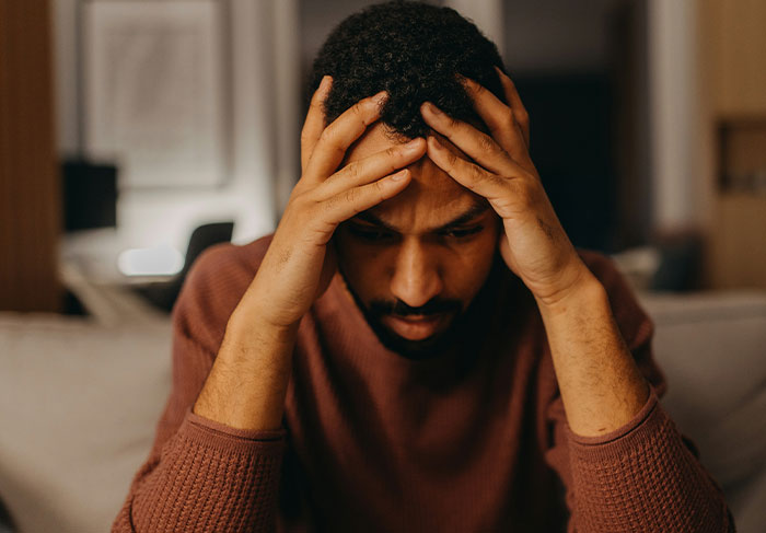 Stressed man holding his head, symbolizing landlord tenant disputes and stress