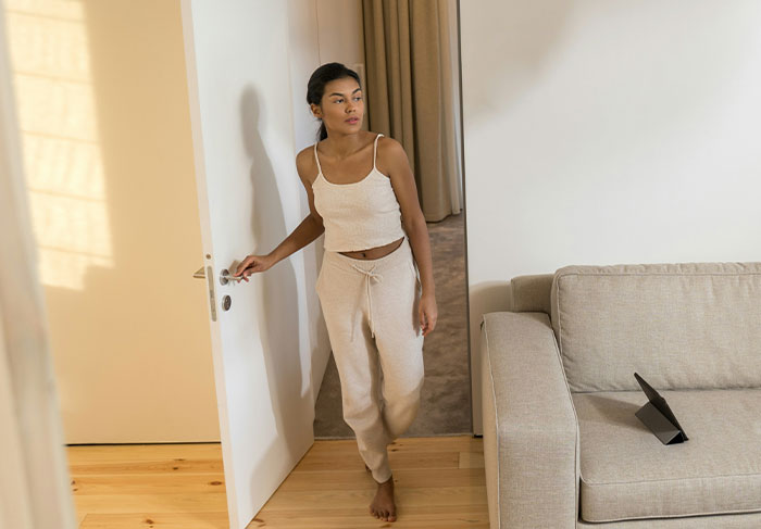 Tenant entering apartment with cautious expression in rental property