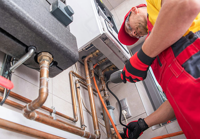 Technician repairing plumbing pipes in rental property maintenance service