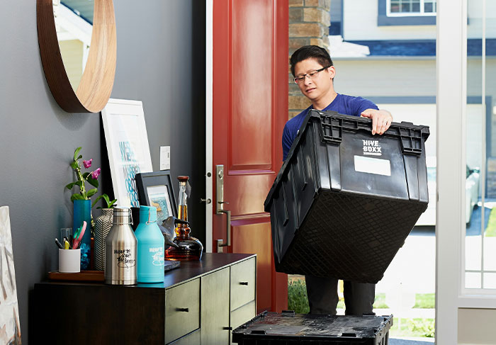 Man carrying moving box symbolizing tenant moving out due to landlord issues