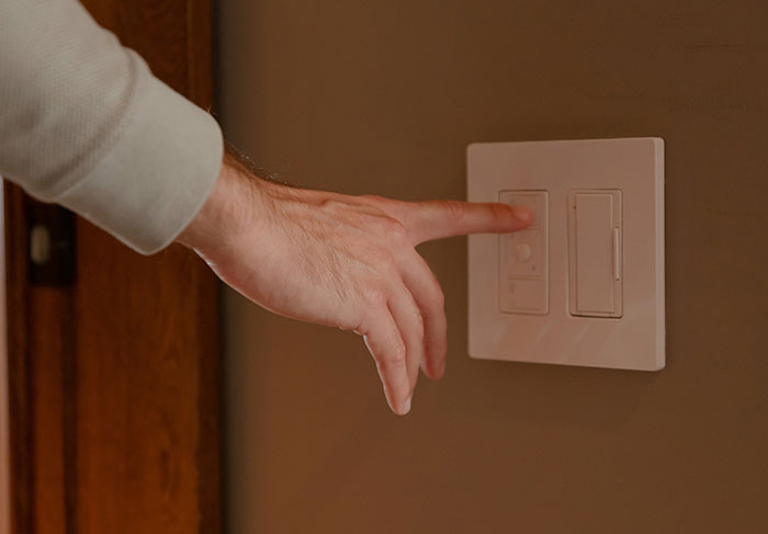 Hand reaching to turn off light switch showing tenant living conditions
