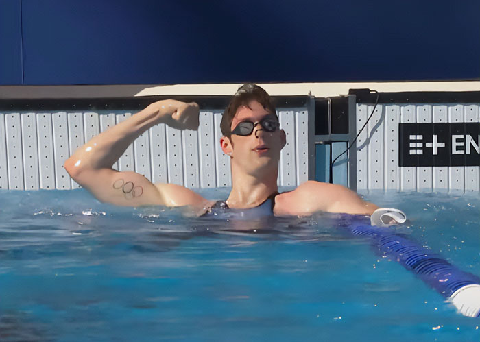 Swimmer flexing arm at Steroid Olympics poolside