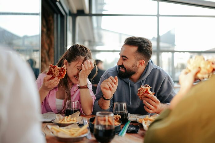 Friends laughing while eating burgers and fries, exposing everyday privilege and showing ignorant things middle-class people say.