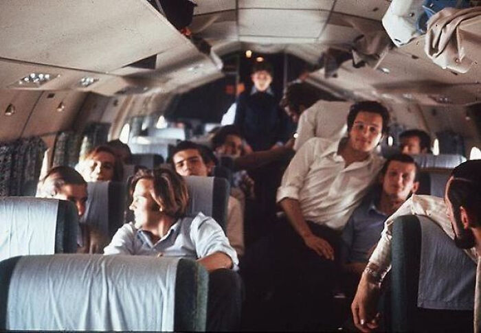 Group of people inside airplane with one suspicious figure