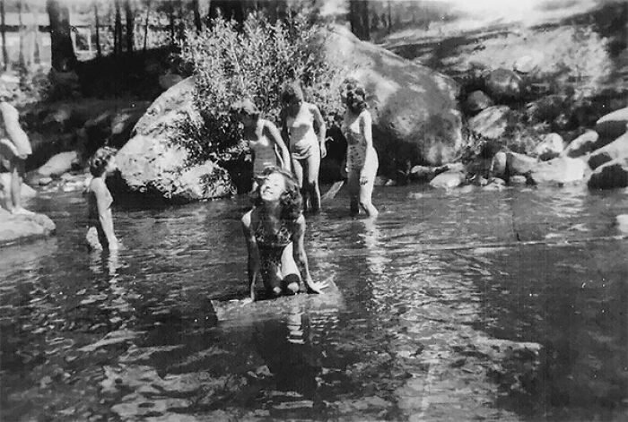 Black and white photo of children playing in water with an unusual shadow