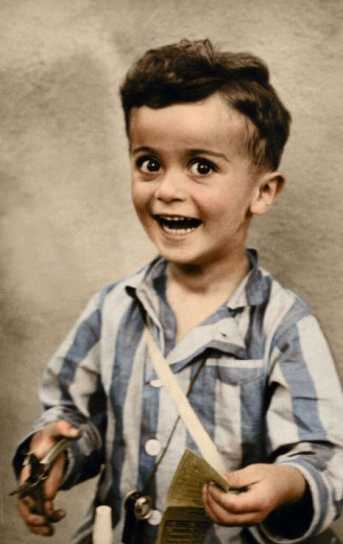 Vintage photo of a creepy boy in striped pajamas holding objects with intense eyes