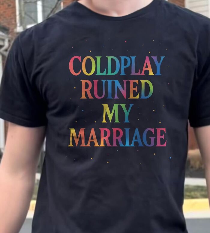 A person wearing a black t-shirt with colorful text that reads, Coldplay Ruined My Marriage, illustrating a bizarre t-shirt.
