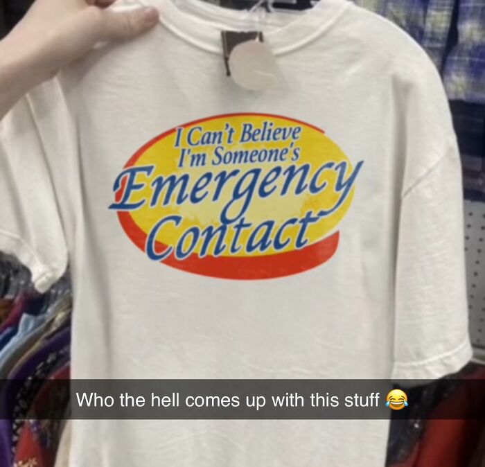 Someone holding an unhinged T-shirts that says I Can't Believe I'm Someone's Emergency Contact, brilliant and bizarre.