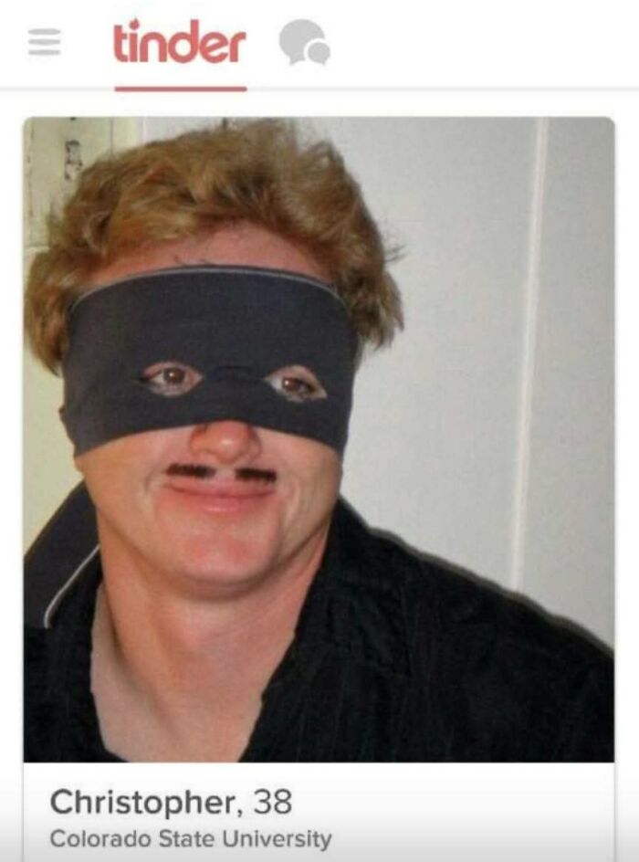 Man in a black eye mask and mustache on Tinder profile, illustrating confused market value meme