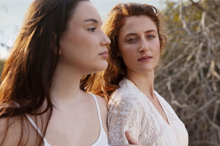 Two women standing outdoors showing emotional connection Two women standing outdoors showing emotional connection