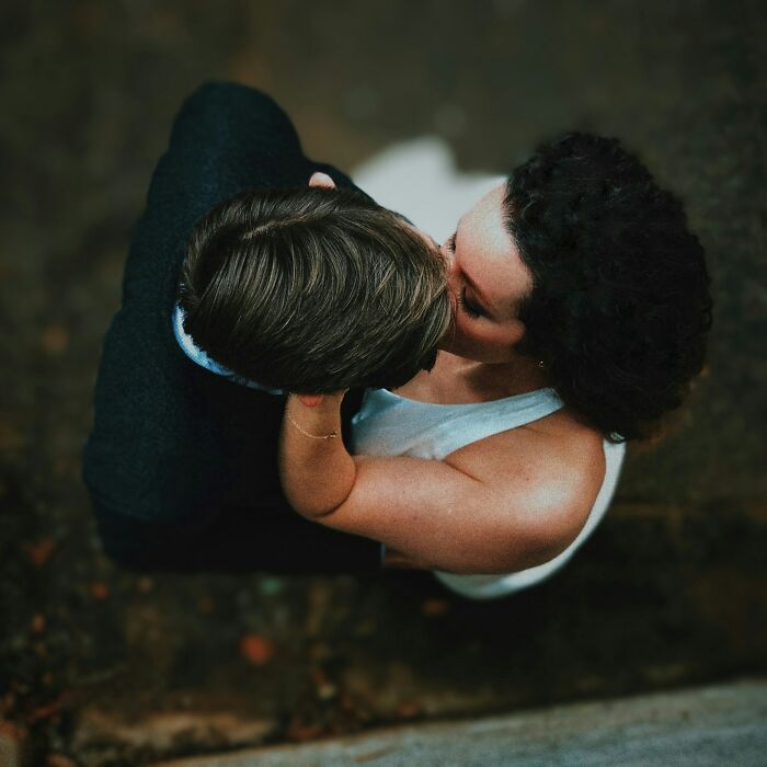 Overhead view of couple kissing outdoors in romantic wedding photography moment