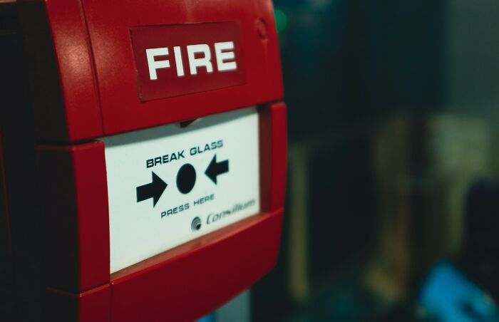 Red fire alarm with break glass panel for emergency use