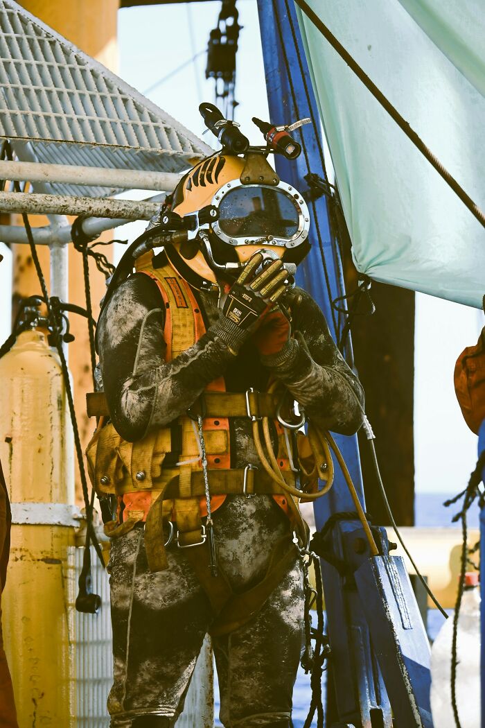 A fully equipped diver in a heavy yellow helmet and suit, highlighting disturbing d***h stories from the deep.