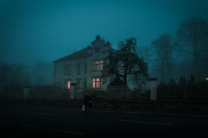 Spooky old house at night with glowing windows and foggy atmosphere terrifying experience