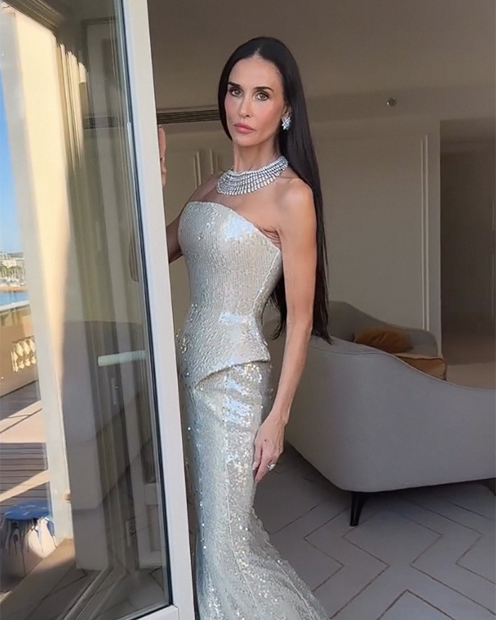 Joan Collins em vestido de lantejoulas posando dentro de casa perto da varanda
