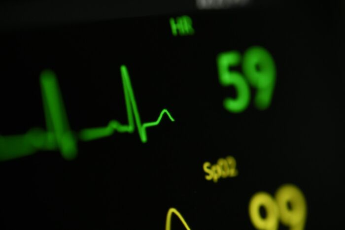 Close-up of hospital heart rate monitor displaying vital signs