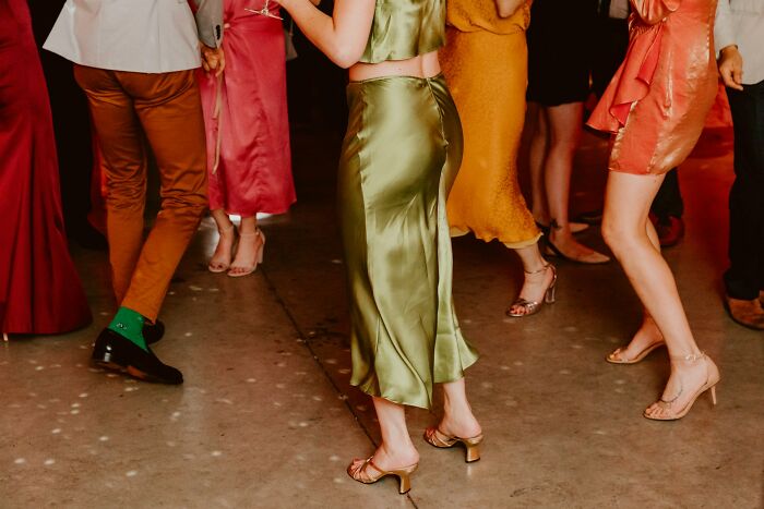 Guests dancing at wedding reception in colorful elegant attire on dance floor