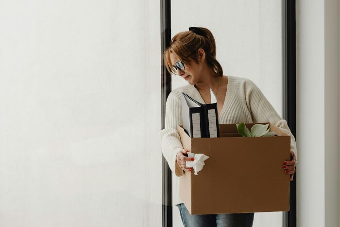 Woman carrying a box of office items after quitting job