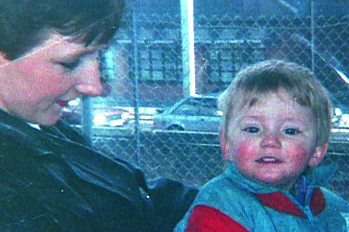 Child with adult near chain-link fence in lost child photo