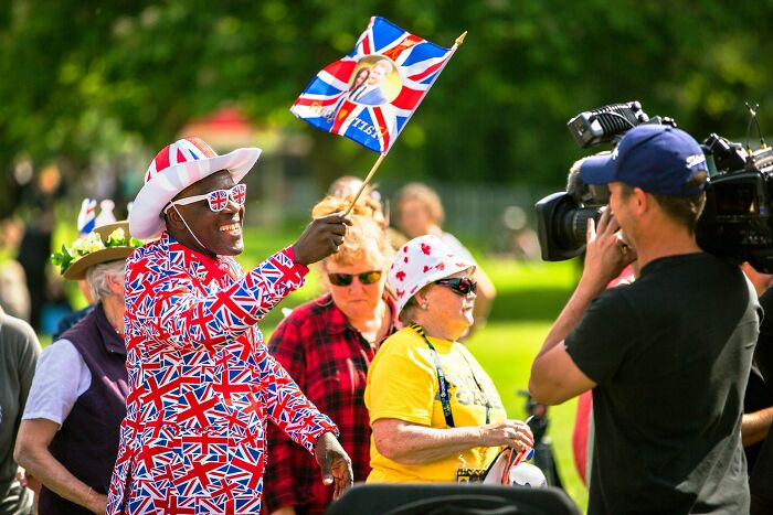 Man dressed in Union Jack outfit waves British flag during Great British vocabulary test event