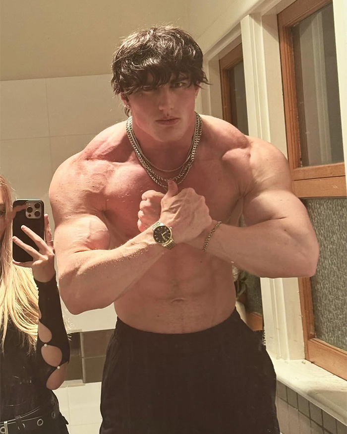 Muscular looksmaxxer posing shirtless with chains and watch